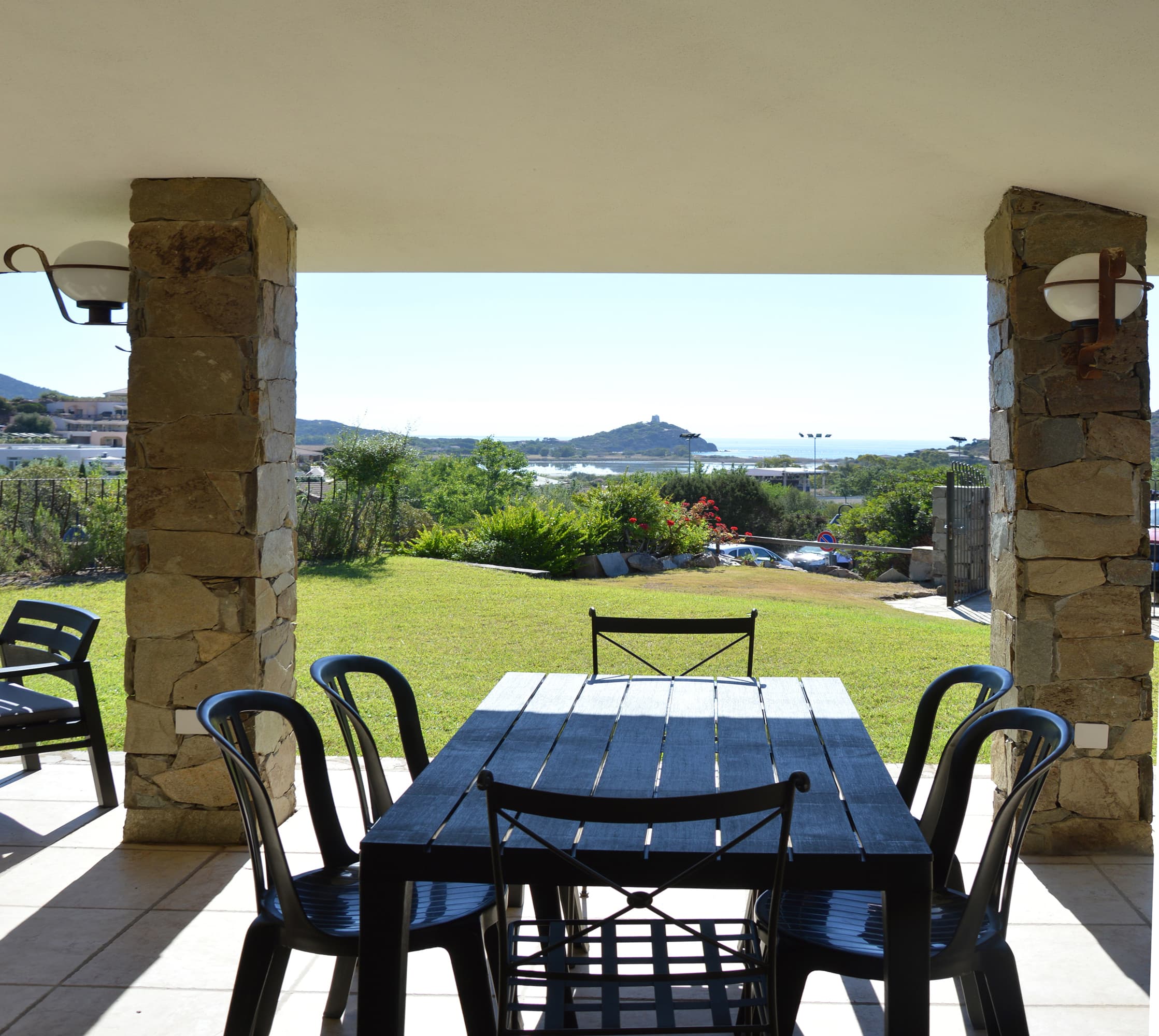 Veranda in pietra della casa con giardino e vista mare e torre di Chia